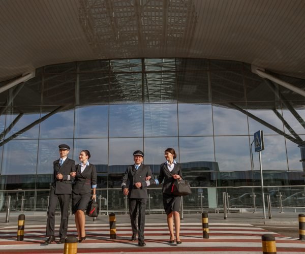 Flight team crossing the road outdoor with terminal on the background